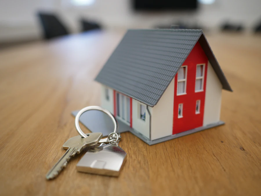 Chaveiro com chaves ao lado de miniatura de casa
