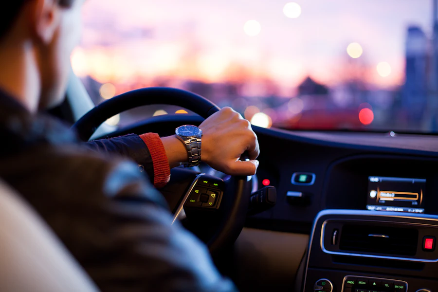 Motorista ao volante de um carro ao entardecer